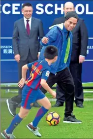  ?? YANG GUANYU / XINHUA ?? Ronaldo de Assis Moreira, an ambassador of FC Barcelona, instructs a young player at a training center in Haikou, Hainan province.