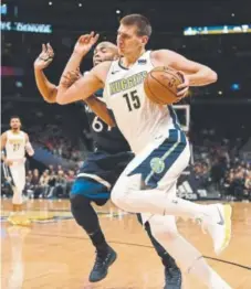  ?? John Leyba, The Denver Post ?? Nuggets center Nikola Jokic attempts to drive past Timberwolv­es forward Taj Gibson during the first quarter of Wednesday’s game at Pepsi Center. The Nuggets lost 112-104.