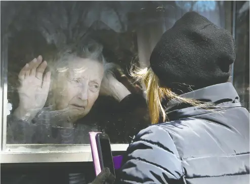  ?? VERONICA HENRI / POSTMEDIA NEWS FILES ?? Diane Colangelo visits her 86-year-old mother Patricia through a window at the Orchard Villa long-term care home
in Pickering not long after the COVID pandemic began in 2020. Both daughter and mother were in tears.