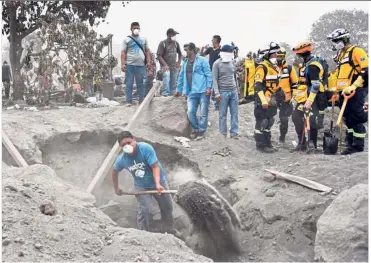  ?? — AFP/Reuters ?? Grim task: Residents and members of Mexico’s Tlatelolco Moles rescue team taking part in the search for victims in the ash-covered village of San Miguel Los Lotes in Escuintla. (Below) A man who lost 13 family members being comforted by a volunteer after remains were found at his home.