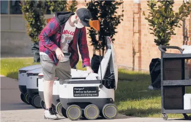  ?? CARLOS OSORIO/AP ?? Food is loaded into a robot Oct. 13 at the Bowling Green State University campus in Bowling Green, Ohio.