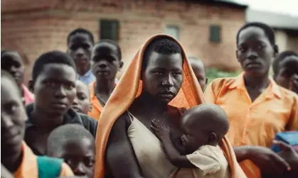  ?? ?? A crowd watches the internatio­nal criminal court case against Dominic Ongwen on television in a Ugandan village. Photograph: Kacper Czubak