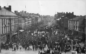  ?? H.C. GOODMAN RON GOODMAN ?? As bells ring out, people begin to flood into downtown St. Catharines, led by night-shift workers at the Steel &amp; Metal Co. plant on Geneva Street, soon followed by workers from McKinnon Industries.