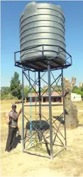  ?? ?? Mr Magondo stands next to a water storage tank mounted to ensure adequate supply of the precious liquid at Gwangwadza Business Centre