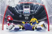  ?? THE ASSOCIATED PRESS ?? Canada forward Sidney Crosby, left, scores past Sweden goaltender Henrik Lundqvist during the men’s gold medal ice hockey game at the 2014 Winter Olympics in Sochi, Russia.