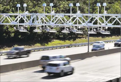  ?? Associated Press file photo ?? Cars pass under toll sensor gantries hanging over the Massachuse­tts Turnpike in Newton, Mass., in August 2016.