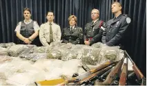  ?? FILES ?? Police officers from the RCMP, Quebec and Ontario stand behind a table loaded with money, drugs and guns, confiscate­d in raids that dismantled an operation headed by Raymond Desfossés, at a news conference in 2004. Desfossés is now seeking permission...