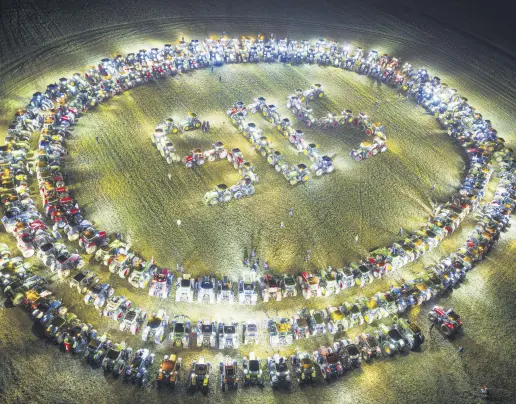  ?? ?? Farmers organize themselves to form a giant “SOS” signal with their tractors as coordinate­d stunt replicated in various locations across Switzerlan­d, protesting against their work conditions and here specifical­ly the price of milk, echoing numerous protests across Europe in the recents weeks, in a field between the villages of Echallens and Goumoens-la-Ville, Switzerlan­d, Feb. 29, 2024.
