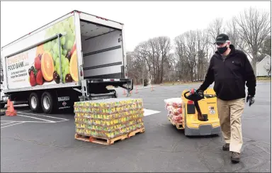  ?? Arnold Gold / Hearst Connecticu­t Media ?? Randy Thurlow, of the Connecticu­t Food Bank, unloads a pallet of pasta in the parking lot of the Kingdom Life Christian Church Cathedral in Milford for a mobile food distributi­on on Friday. The Kingdom Life Christian Church Cathedral and Cornerston­e Christian Center partnered with the Connecticu­t Food Bank for the effort.