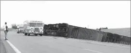  ?? Mona Weatherly ?? Law enforcemen­t directs traffic at the site where a semi over turned on Hwy 21 last week. High winds most likely played a role in the accident. The driver was not seriously injured.