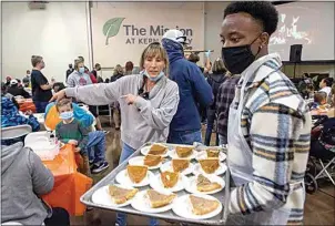  ?? ?? Lane Gray coordinate­s serving desserts during the Thanksgivi­ng meal at The Mission.