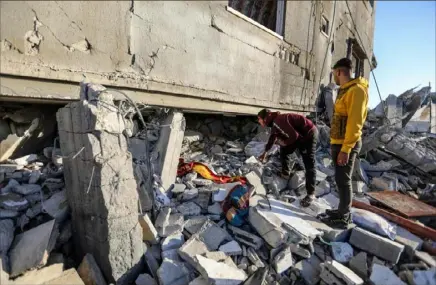  ?? Ahmad Hasaballah/Getty Images ?? People inspect damage and recover items from their homes Friday following Israeli airstrikes in Rafah, Gaza. The United States and other nations mediating Israel-Hamas cease-fire talks had hoped to reach a temporary truce prior to the start of the Islamic holy month, but recent meetings in Cairo did not produce a result.