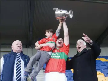  ??  ?? Rathnew captain Charlie Cruse holds the cup and Shay Melia aloft as Pat Mitchell and Pat Dunne look on.