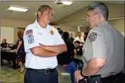  ??  ?? BELOW: Brothers Dave Roberson (right), a captain with the Floyd County Sheriff’s Office, and Brad Roberson, chief of operations for the Rome-Floyd fire department, have a rare chat during working hours Tuesday.