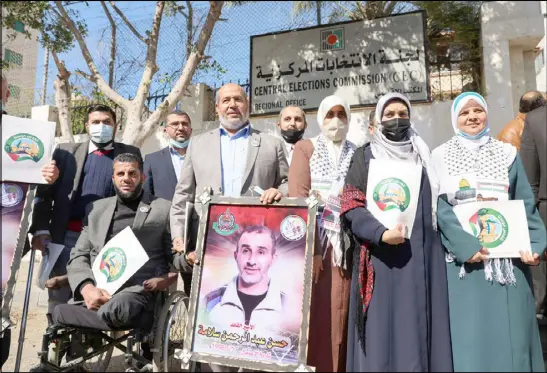  ??  ?? عضو المكتب السياسي خليل الحية )وسط( ومؤيدون لحماس خارج إحدى لجان الانتخابات في غزة