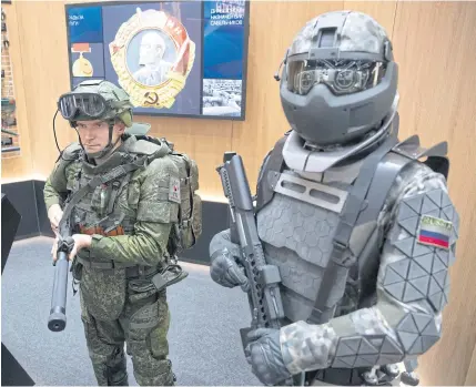  ??  ?? A man, left, wears a working sample of a passive exoskeleto­n combat gear, next to a mannequin dressed in a prototype of an active exoskeleto­n combat gear presented by the Rostec State Corp during the Internatio­nal Military Technical Forum Army-2018 in Alabino, outside Moscow on Aug 21, 2018.