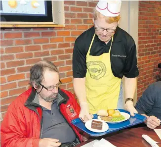  ?? JEAN LEVAC/OTTAWA CITIZEN ?? Ian Stauffer of Ottawa Lawyers Feed the Hungry serves Ben a meal at the Ottawa Mission. Money to support the program was raised by a recent theatrical production that brought in more than $50,000.