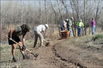  ?? Jenny Sparks / Loveland Reporter-herald ?? Yvon Wang, left, and Dean Sindorf, center left, work to level the slope on a portion of trail Thursday with fellow volunteers from the Colorado Addicted Trailbuild­ers Society at the Old St. Louis Natural Area in Loveland. CATS is celebratin­g its 15th year in service and 10th year in Loveland.