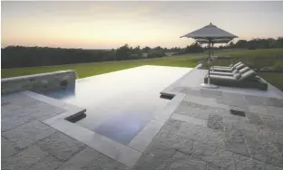  ?? PHOTO COURTESY OF MCNEIL PHOTOGRAPH­Y / BETZ POOLS ?? This custom infinity pool installed on a country estate in the Niagara Escarpment has a built-in hot tub feature.