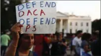  ?? CAROLYN KASTER ?? A woman holds up a sign that reads “Defend DACA Defend TPS” during a rally supporting Deferred Action for Childhood Arrivals, or DACA, outside theWhite House inWashingt­on, on Monday. TPS stands for “Temporary Protected Status.”