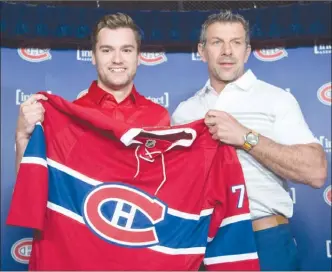  ?? The Canadian Press ?? Newly acquired Montreal Canadiens forward Jonathan Drouin, left, gets his jersey from general manager Marc Bergevin as he is introduced to the media during a press conference at the Bell Centre in Montreal on Thursday. That trade from Tampa Bay — and...