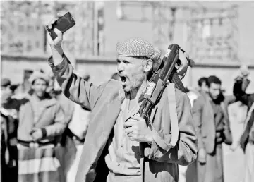  ?? — AFP photo ?? File photo shows a Yemeni man holding an AK-47 as people gather in the capital Sanaa to show their support to the Shiite Huthi movement against the Saudi-led interventi­on.