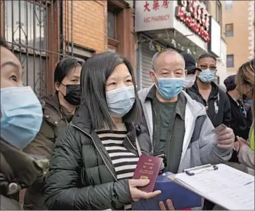  ?? Mark Lennihan Associated Press ?? RESTAURANT AND delivery workers ask for help as they sign up for COVID-19 vaccinatio­ns at a mobile site in the Sunset Park neighborho­od of New York. Mayor Bill de Blasio has called for a bigger vaccine allotment.