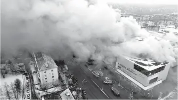  ?? Associated Press ?? ■ In this Russian Emergency Situations Ministry file photo, smoke rises above a multi-story shopping center March 25 in the Siberian city of Kemerovo, about 3,000 kilometers (1,900 miles) east of Moscow, Russia. The deaths more than 50 people in the...