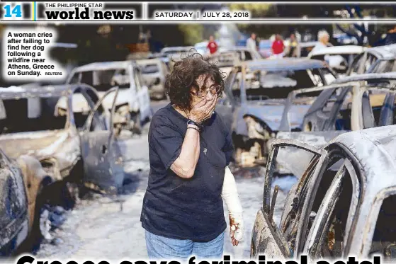  ?? REUTERS ?? A woman cries after failing to find her dog following a wildfire near Athens, Greece on Sunday.