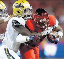  ?? Robert Gauthier
Los Angeles Times ?? JAYON BROWN of UCLA tackles Jared Baker of Arizona in a game this season. Brown moved to inside linebacker last week after a series of injuries to others.