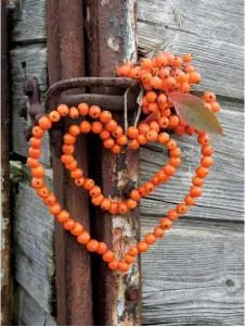  ??  ?? Cheery rowan beads threaded onto wire in a heart shape greet those passing through a garden gate.
