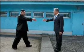  ?? KOREA SUMMIT PRESS POOL VIA AP ?? North Korean leader Kim Jong Un, left, prepares to shake hands with South Korean President Moon Jae-in at the border village of Panmunjom in Demilitari­zed Zone Friday. Their discussion­s will be expected to focus on whether the North can be persuaded to...