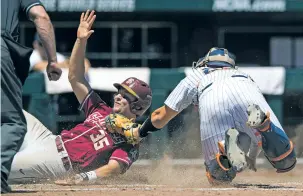  ?? MATT MILLER/ OMAHA WORLD-HERALD VIA AP ?? Florida State’s Cal Raleigh, left, is safe at home Monday after avoiding the tag by Cal State Fullerton catcher Chris Hudgins in the fourth inning of a College World Series game in Omaha, Neb. Florida State eliminated the Titans, 6-4.