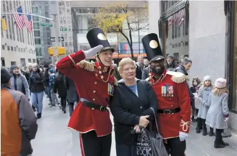  ??  ?? FAO Schwarz employees take photos with customers outside the new store in Rockefelle­r Center in New York. — AFP