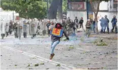  ?? — Reuters ?? A demonstrat­or runs away from riot security force at a rally during a strike called to protest against Venezuelan President Nicolas Maduro’s government in Caracas.
