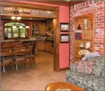  ??  ?? A brick wall adds rustic charm to the den, which is open to the kitchen and breakfast area.