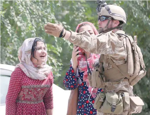  ?? — Reuters ?? Women talk with a US security force officer in Kabul. Trump had not decided whether to go ahead with a withdrawal, which under the draft deal would pull 5,000 of the roughly 13,000 troops from Afghanista­n next year.