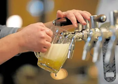  ?? —REUTERS ?? TAPPING TECHNOLOGY A bartender pours beer from a tap at a pub in Prague on Nov. 24.
