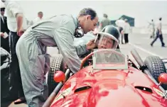  ??  ?? Helping hand: Stirling Moss adjusts Mike Hawthorn’s helmet before a race in 1958