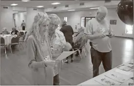  ?? Kevin Myrick / Standard Journal ?? Susan Swafford Wills and Jimmy Smart look at old editions of the Rockmart High School newspaper, the Black and Gold, from their graduating year.