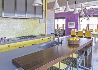  ?? MARCO RICCA/DRAKE/ANDERSON VIA AP ?? Drake/Anderson created this New York City kitchen to flow seamlessly into the main living space by repeating touches of color throughout, echoing the mosaic backsplash pattern in the chair upholstery and running the flooring continuous­ly.