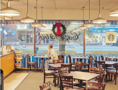  ?? ROSS MANTLE / THE NEW YORK TIMES ?? A patron has a leisurely cup of coffee in the café at Dunham’s Department Store, the only place that sells Starbucks coffee for miles, The Wellsboro, Pa., store usually draws workers in the fracking industry.