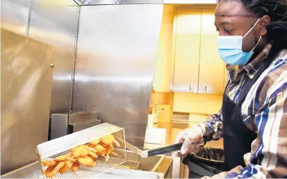  ?? MARY COMPTON/DAILY SOUTHTOWN PHOTOS ?? Tyrone “Ty” Baafour, head chef for the Salvation Army Crossgener­ations Center in Blue Island, prepares fried shrimp Monday for the Senior Lunch program.