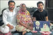  ?? HT PHOTO ?? (From left) Amrik Singh, with mother Angrej Kaur and son Raman Singh, showing a picture of his father Surjit Singh.