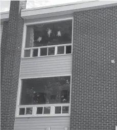  ?? CP PHOTO ?? Evidence markers indicate bullet holes in a window at an apartment building complex on Brookside Drive where four people died in a shooting last Friday in Fredericto­n, N.B.