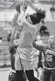  ?? [PHOTO BY JIM BECKEL, THE OKLAHOMAN] ?? OKC Storm senior Raelene Eddens takes a shot while being guarded by Carl Albert players Chae Morbley, left, and Kamiyah Lyons, right, during Thursday’s game in the Carl Albert Titan Classic.