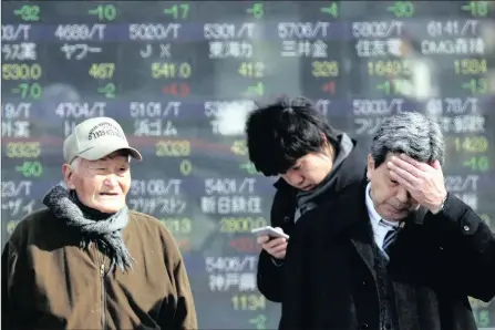  ?? PHOTO: AP ?? People stand by an electronic stock board of a securities firm in Tokyo yesterday. The rand led a wider fall in emerging currencies.