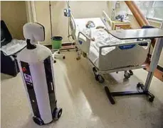  ??  ?? The robot moves around on wheels and has a camera and display screen, enabling relatives and doctors to interact with patients and staff in the wards.