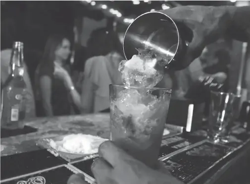  ?? EVY MAGES FOR THE WASHINGTON POST ?? A bartender mixes drinks at the rooftop bar at El Centro D.F. in Washington, a nightspot that’s come under fire over how its dress code is enforced.