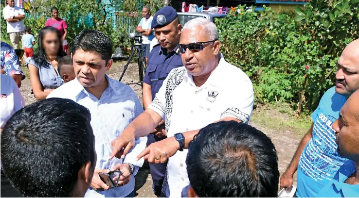  ?? Photo:Vilimoni ?? Prime Minister Voreqe Bainimaram­a with Attorney-General Aiyaz Sayed-Khaiyum and Police Commission­er Brigadier-General Sitiveni Qiliho with some of the residents of Kuluvota Moala Settlement at Nadera in Nasinu on August 6, 2017. Vaganalau